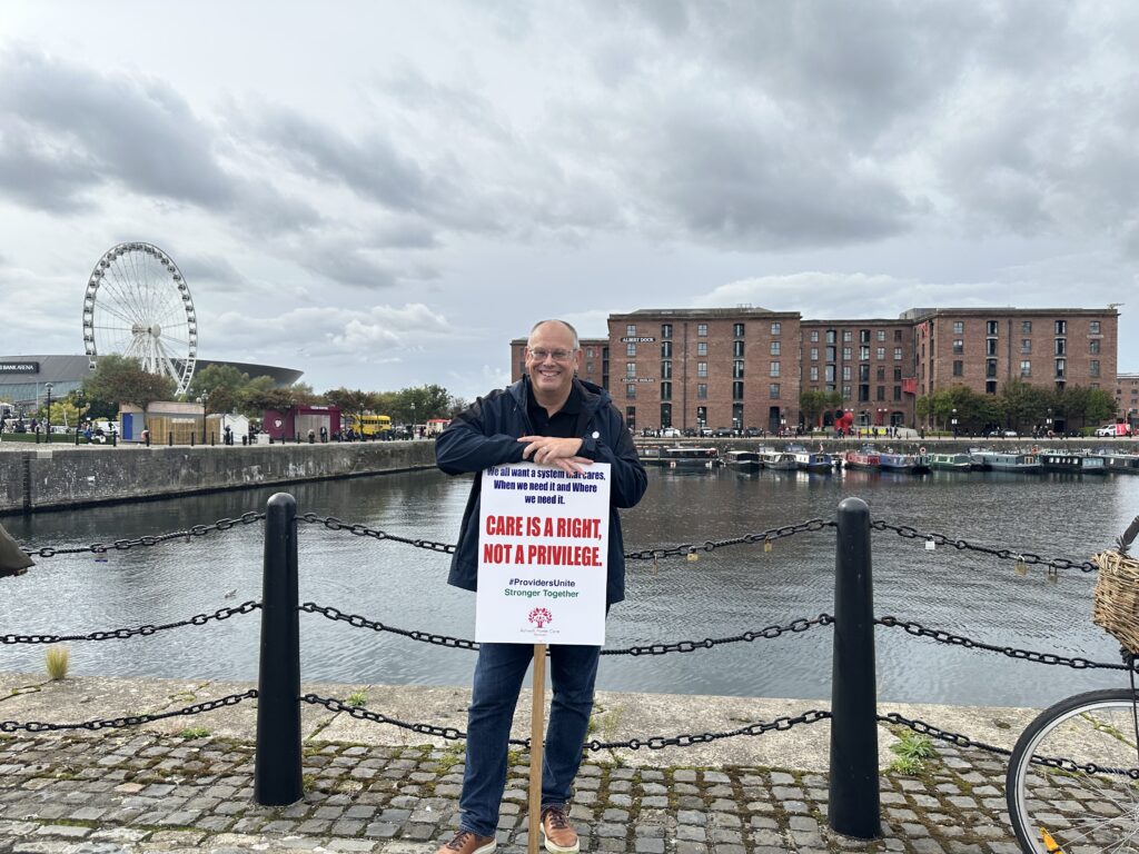 AshwellCare staff Phil Ashwell at a social care march holding a sign
